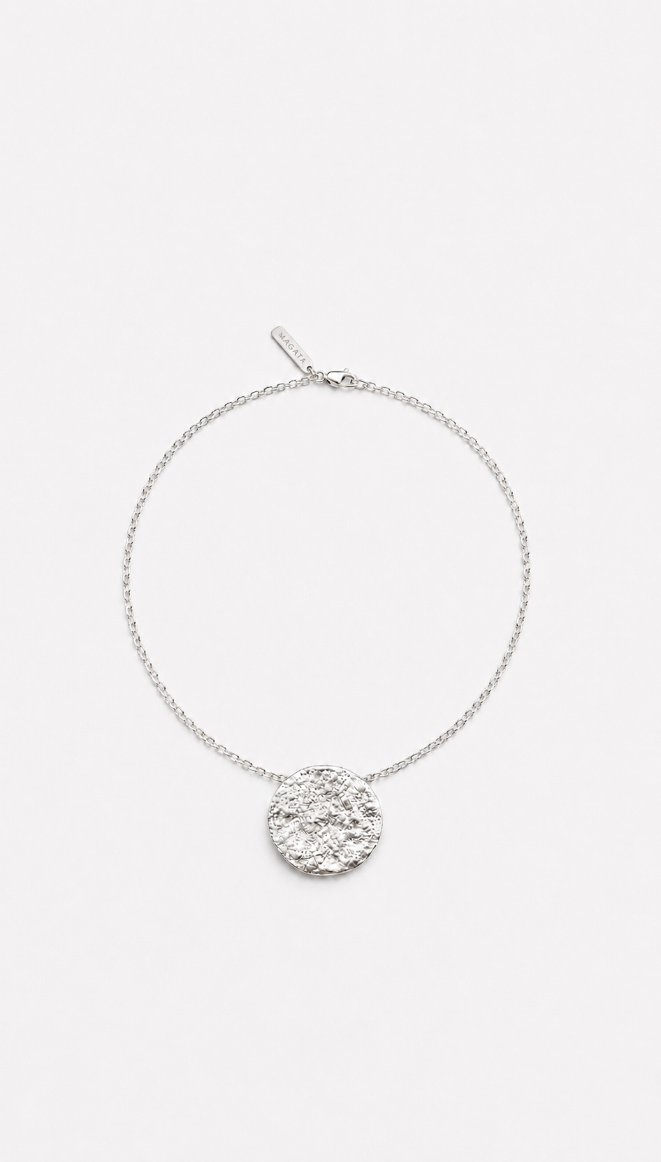 Silver chain necklace with a round moon textured pendant on a white background