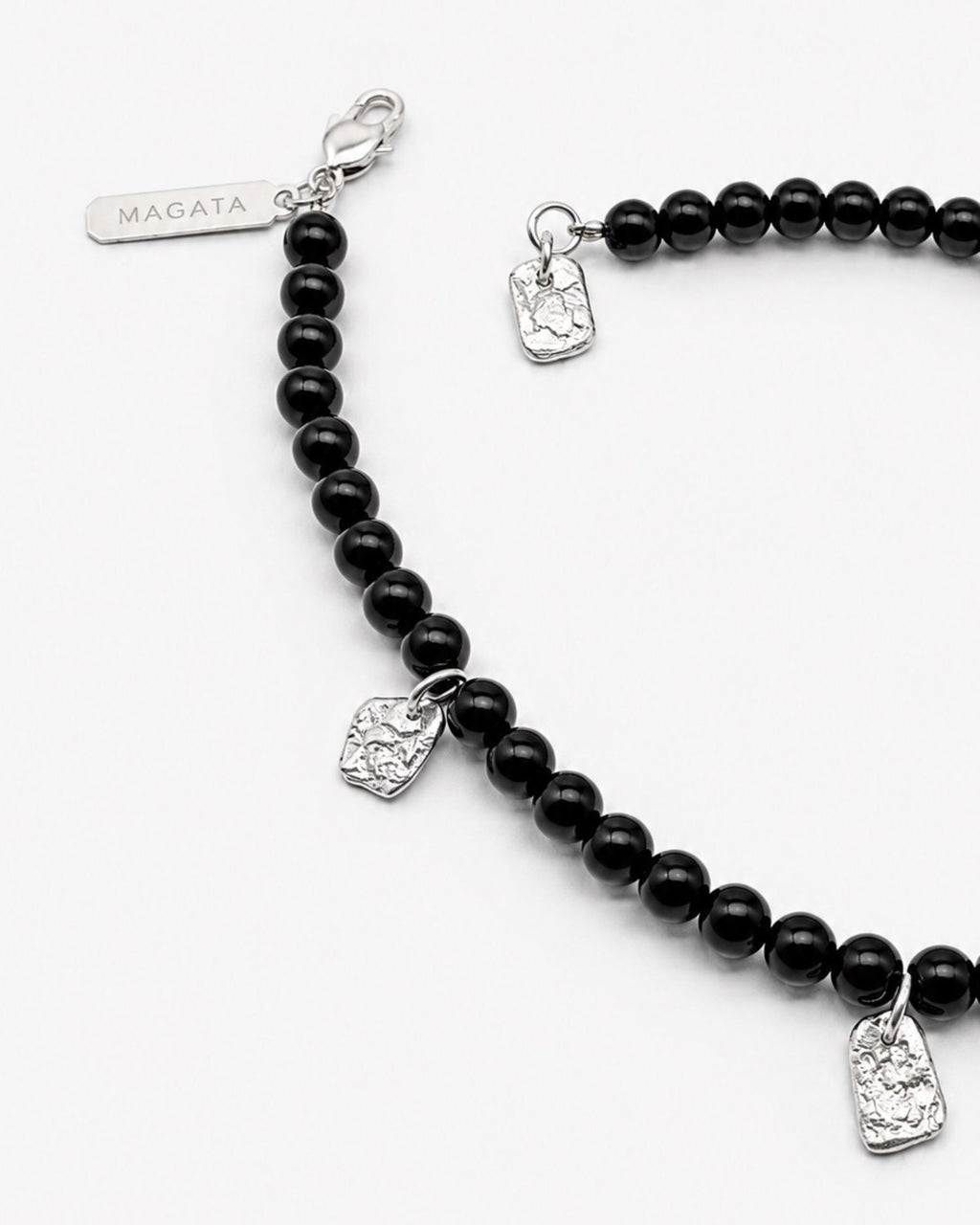 Black beaded bracelet with silver charms on a white background