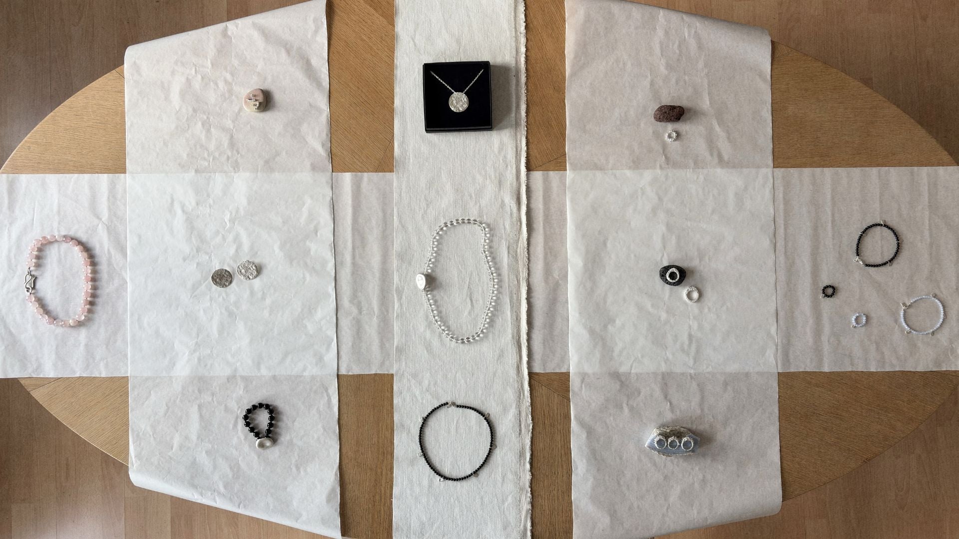 Magata Jewelry displayed on a checkered cloth with a wooden surface underneath